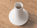 White ceramic vase on a wooden surface