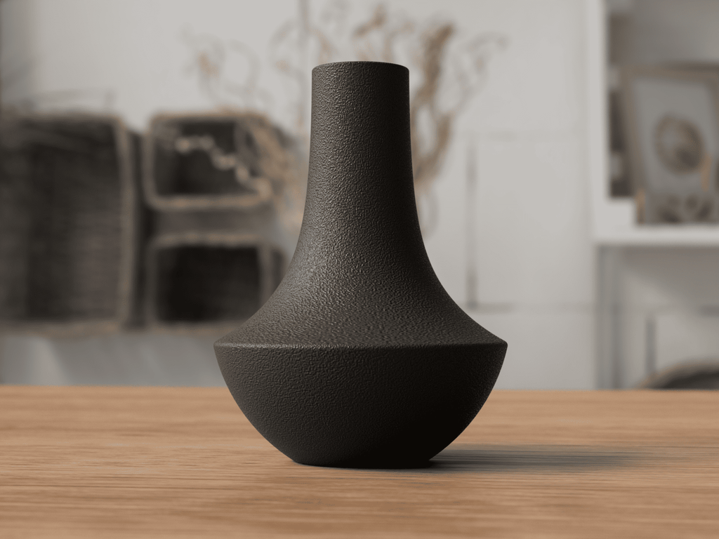 Black textured vase on a wooden surface with a blurred indoor background
