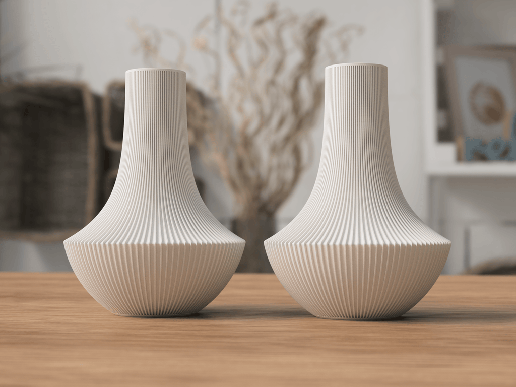 Two white textured vases on a wooden surface with a blurred indoor background