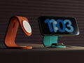 Smartphone on a stand displaying the time with an orange stand on a dark background