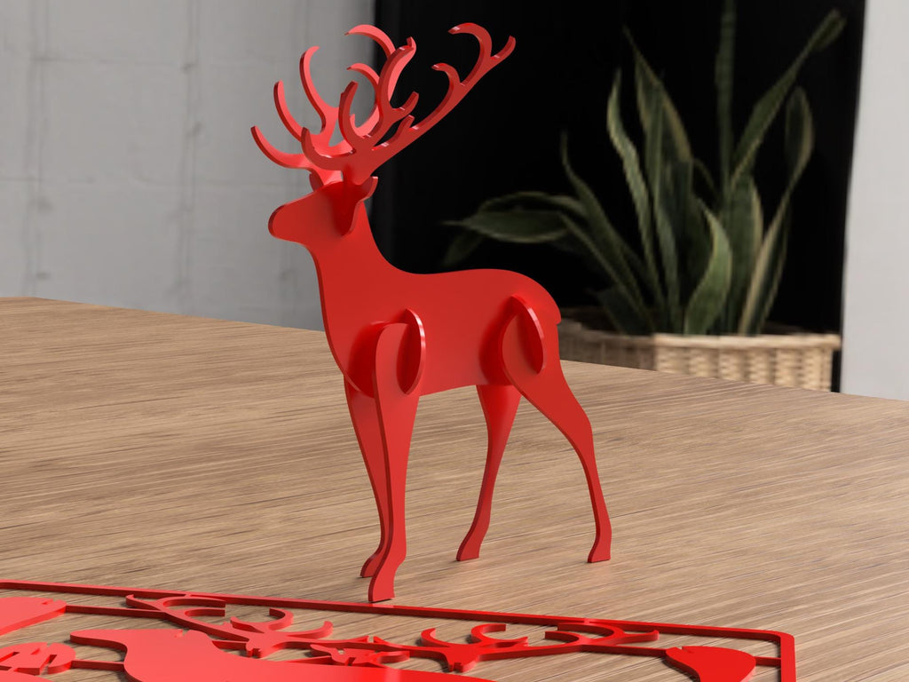 Red deer-shaped decorative item on a wooden surface with a plant in the background.