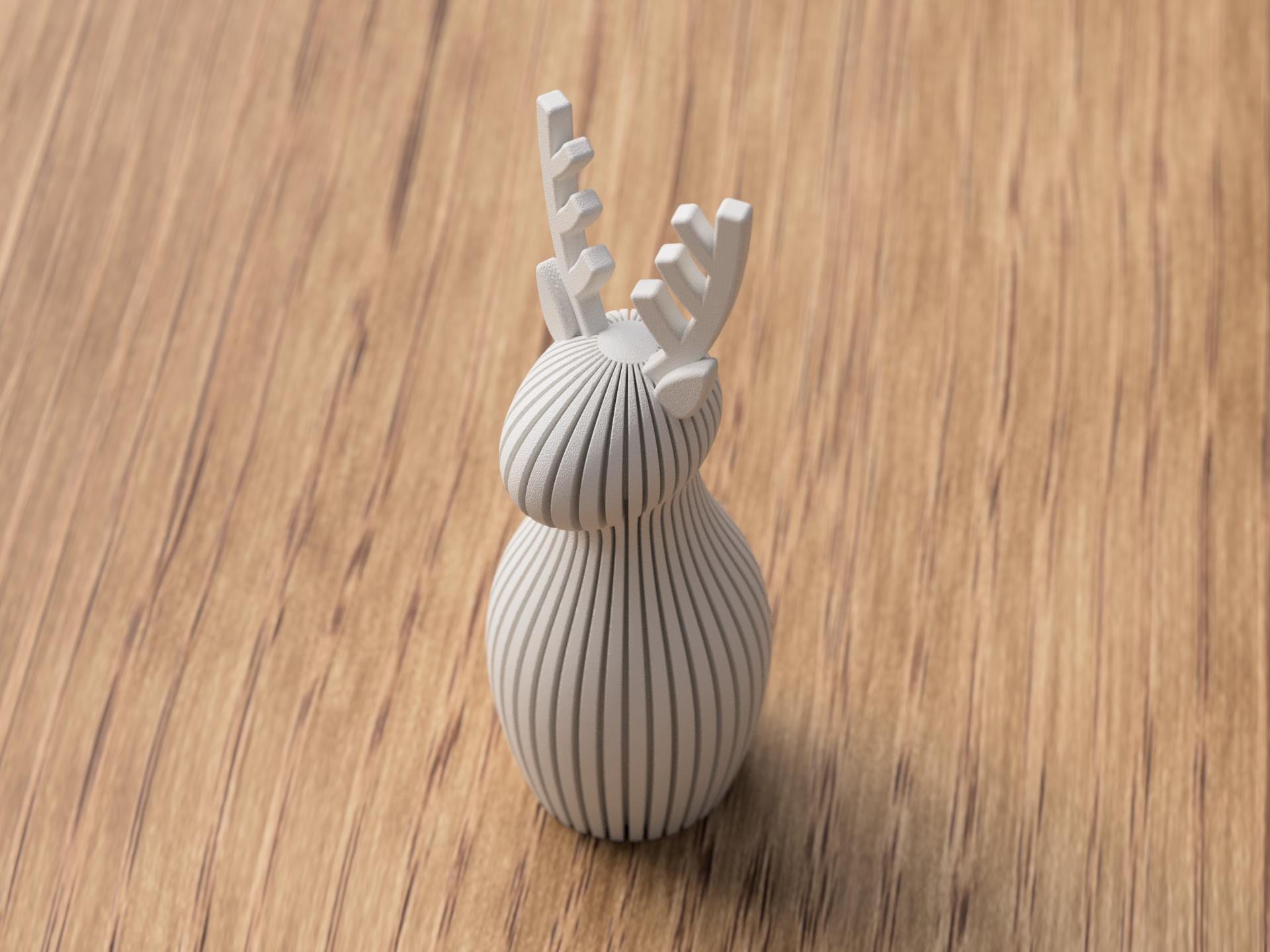 White ceramic deer figurine on a wooden surface