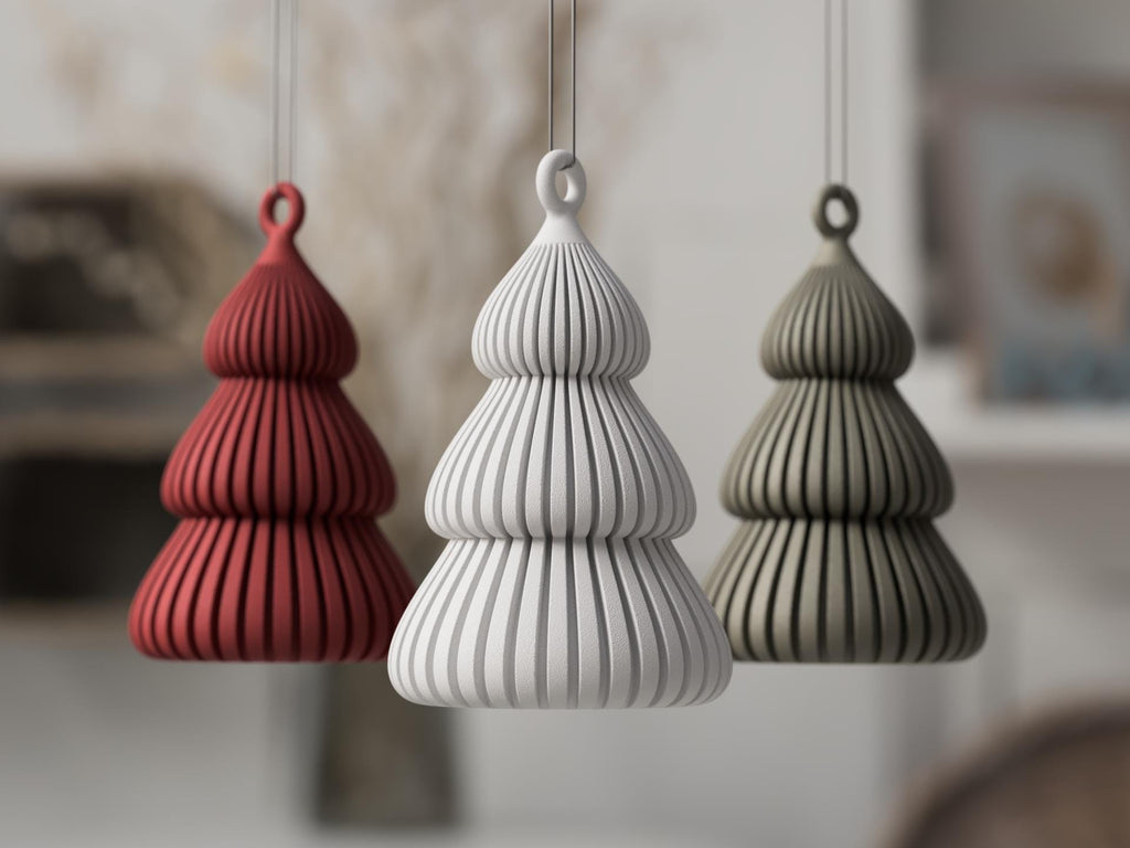 Three textured ceramic ornaments in red, white, and gray hanging against a blurred indoor background.