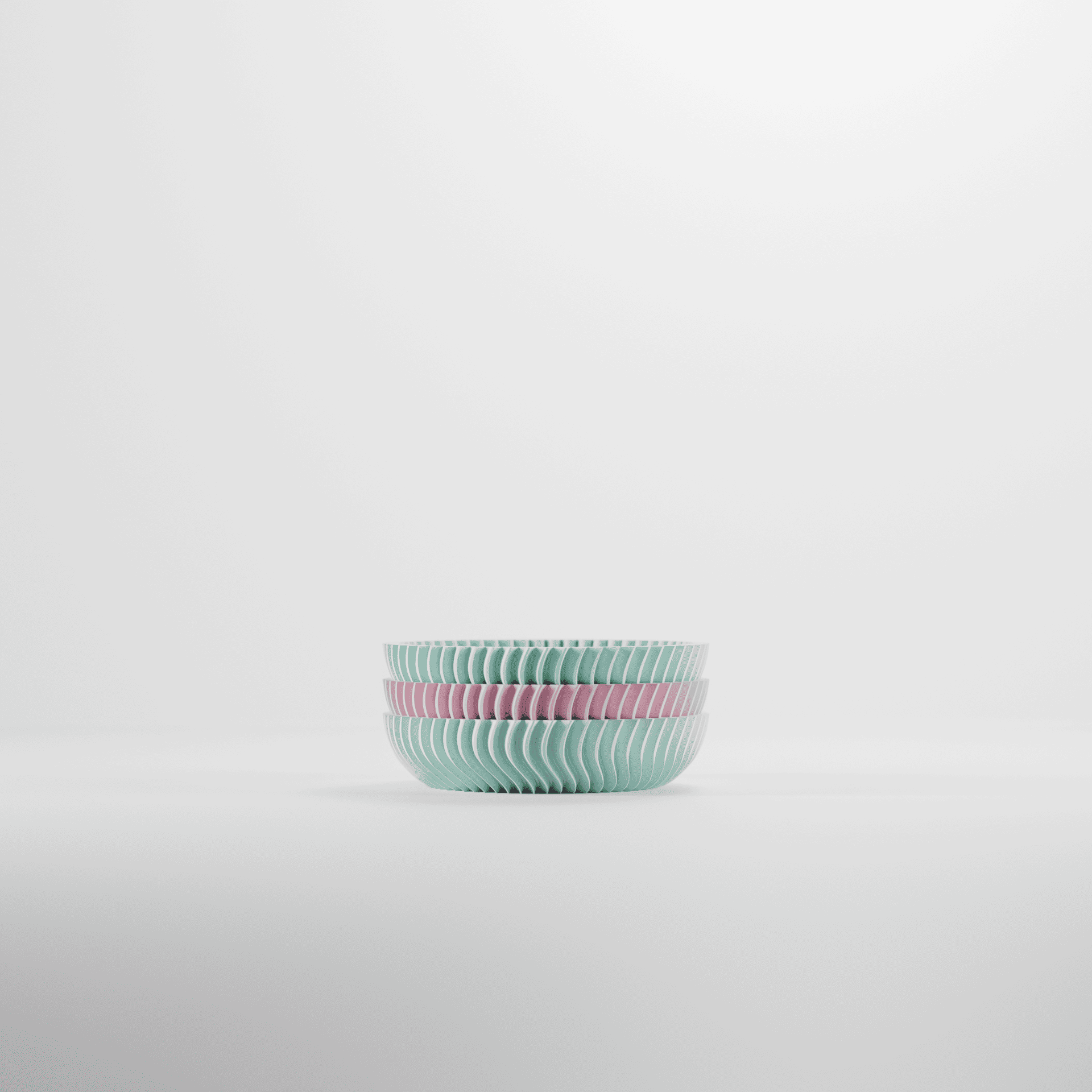 Set of two ribbed ceramic bowls in pastel green and pink on a light gray background
