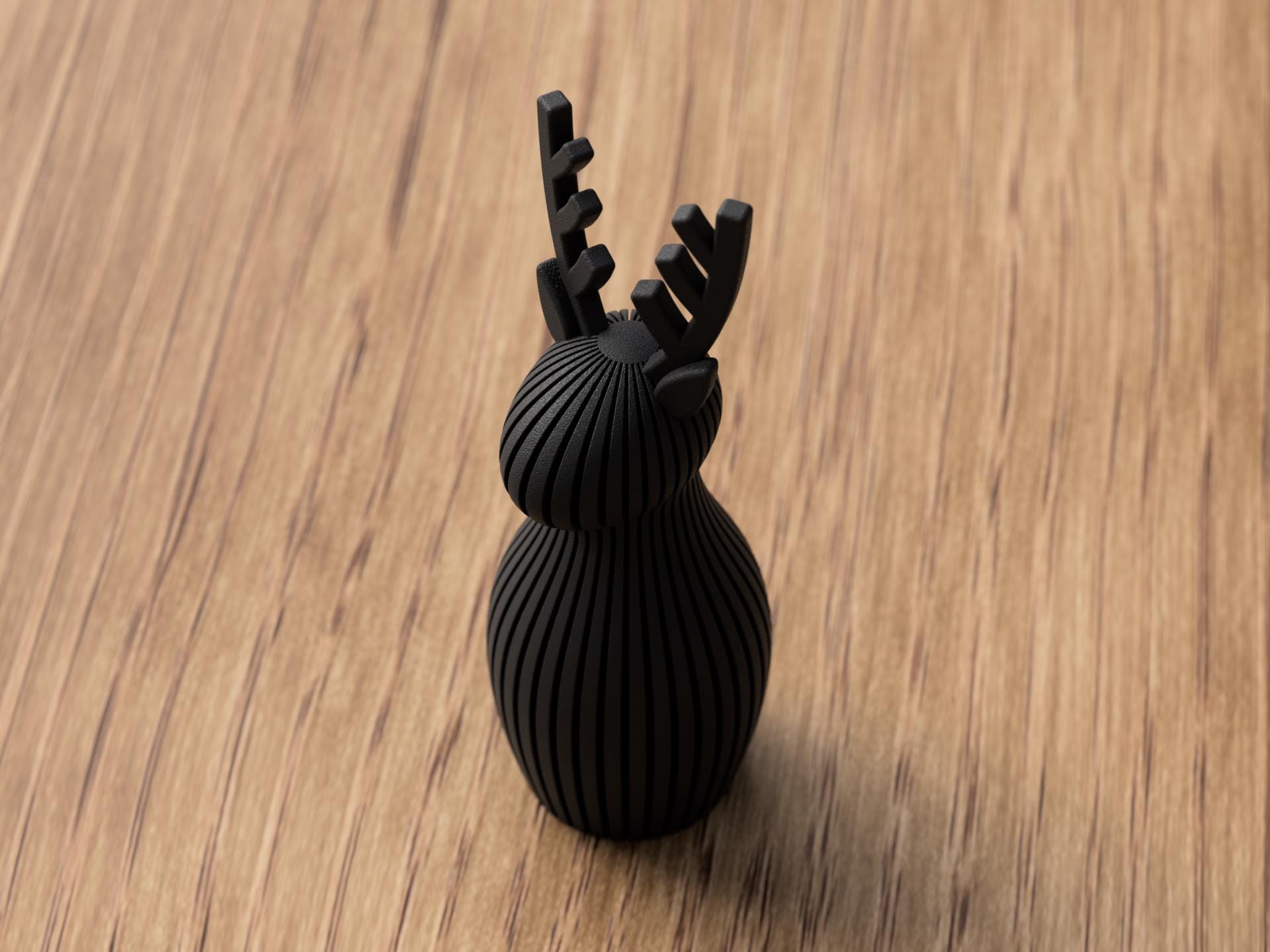 Black reindeer-shaped object on a wooden surface