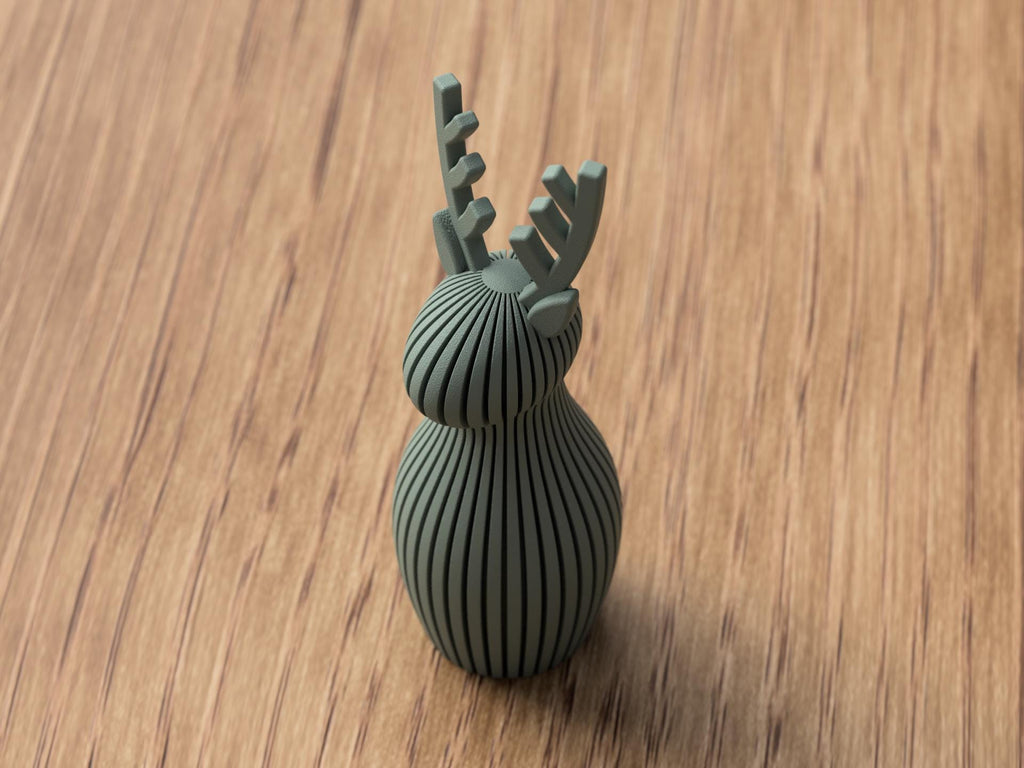 Green ceramic deer-shaped object on a wooden surface