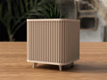 Beige textured planter with a plant on a wooden surface