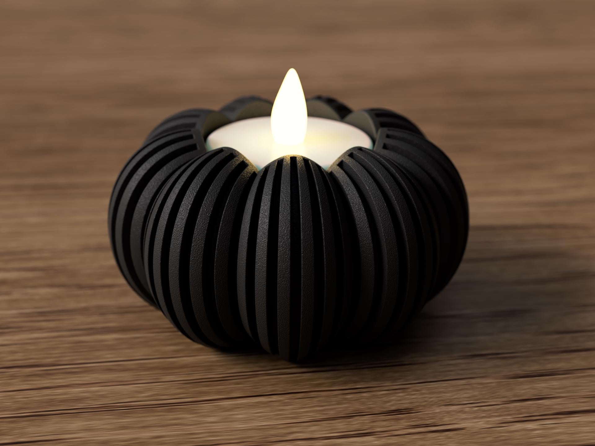 Black ribbed candle holder with a lit candle on a wooden surface