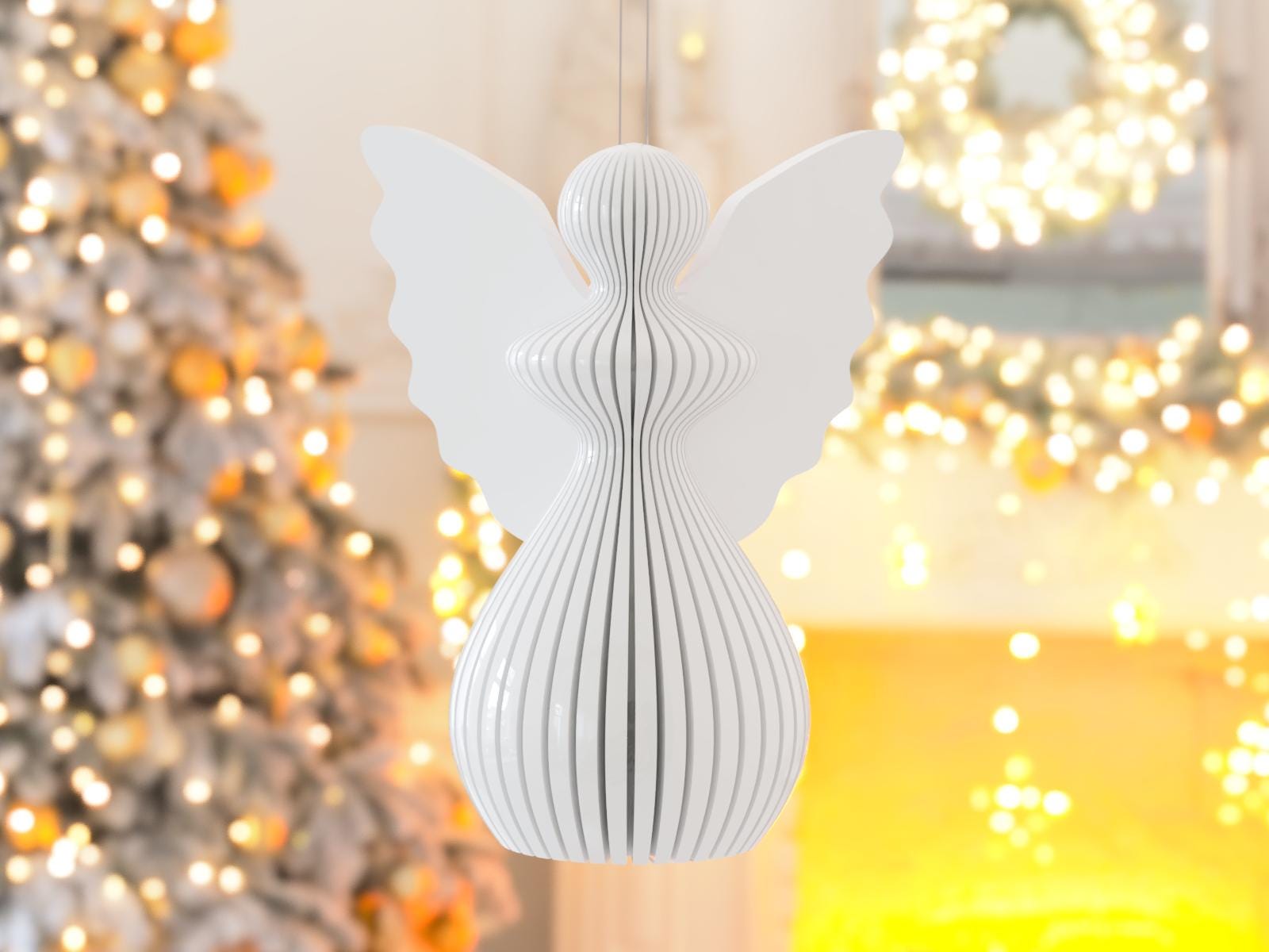 White angel-shaped ornament with blurred festive lights in the background
