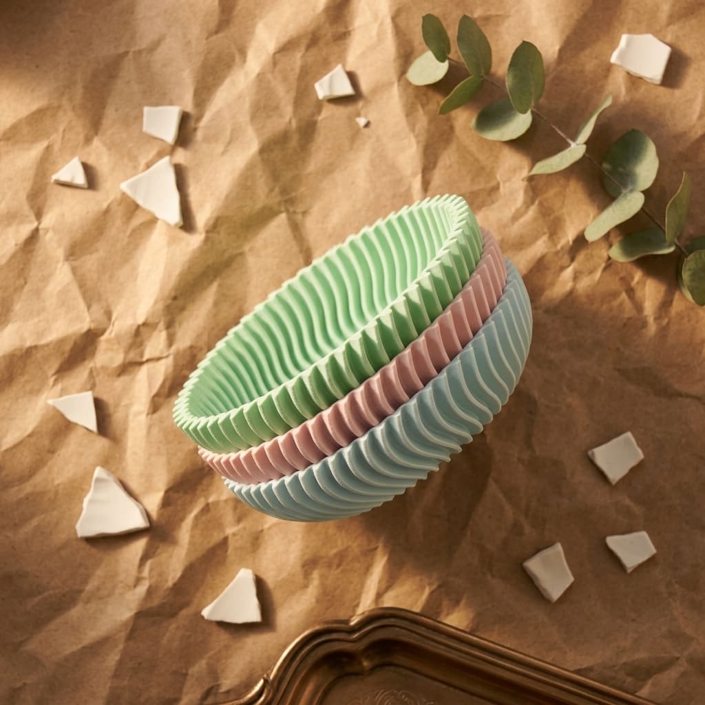 Stack of colourful ceramic style bowls on a textured surface with decorative elements